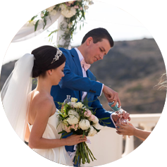 Photo of a beautifully dressed wedding couple with flowers on Paros