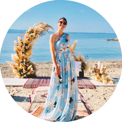 Photo of presenter Tatyana standing against the backdrop of the island of Corfu